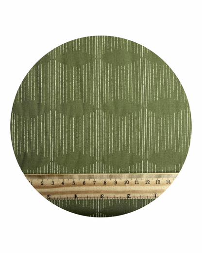 A round fabric swatch of Dream Weaver Potager from Potager Collection for Art Gallery Fabrics, with a wooden ruler in centimeters for scale, on a white background.