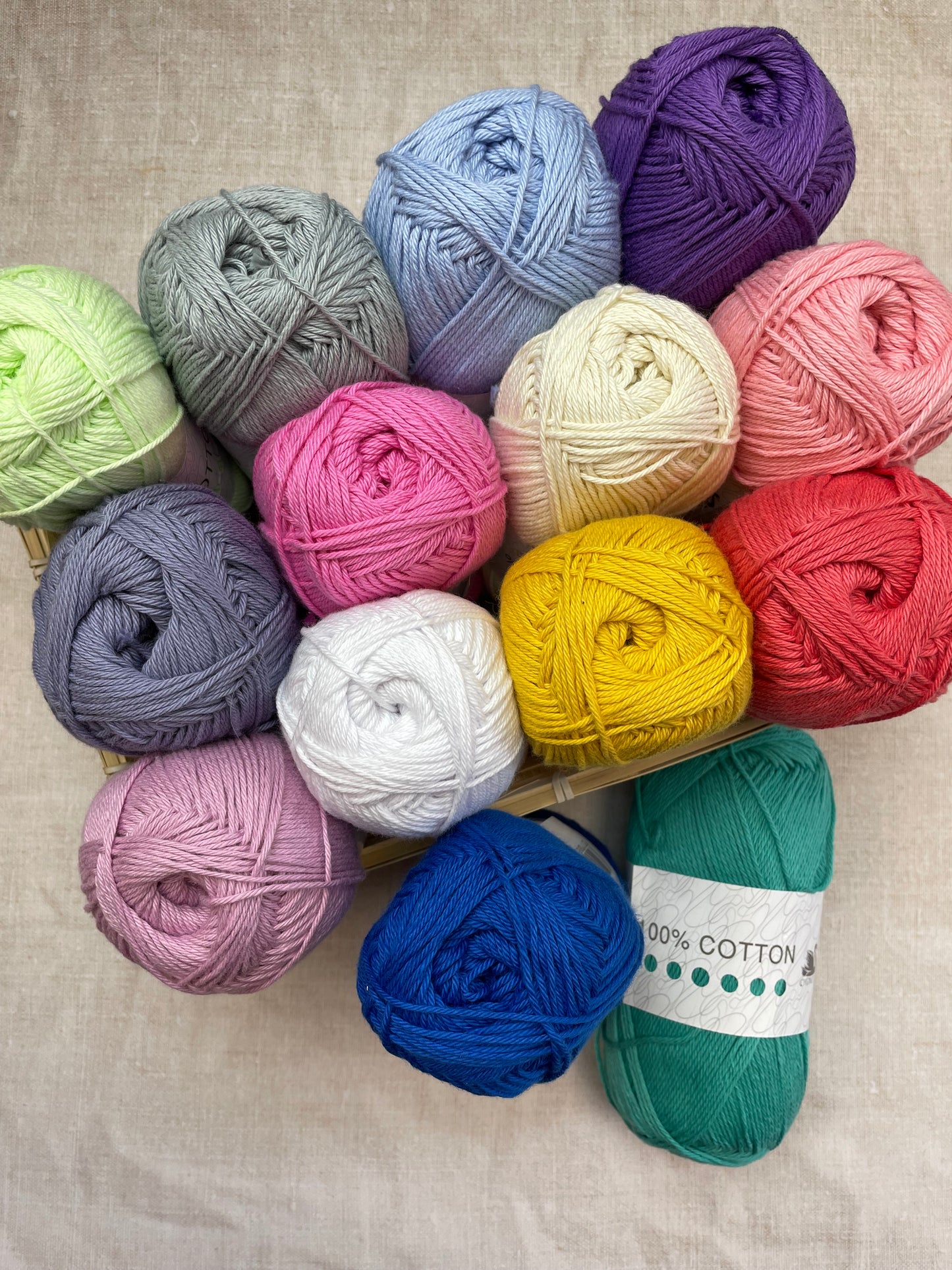 assortment of cygnet cotton yarn on a neutral surface and wooden box.