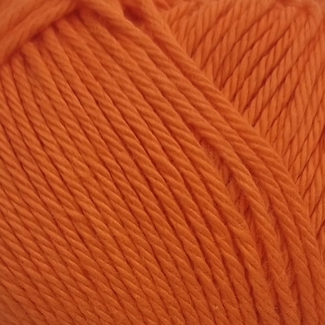 close up of orange ball of cotton  yarn. bright orange wool. 