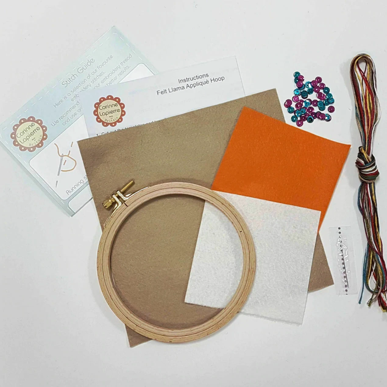 Embroidery hoop with fabric samples and sewing supplies on a white background