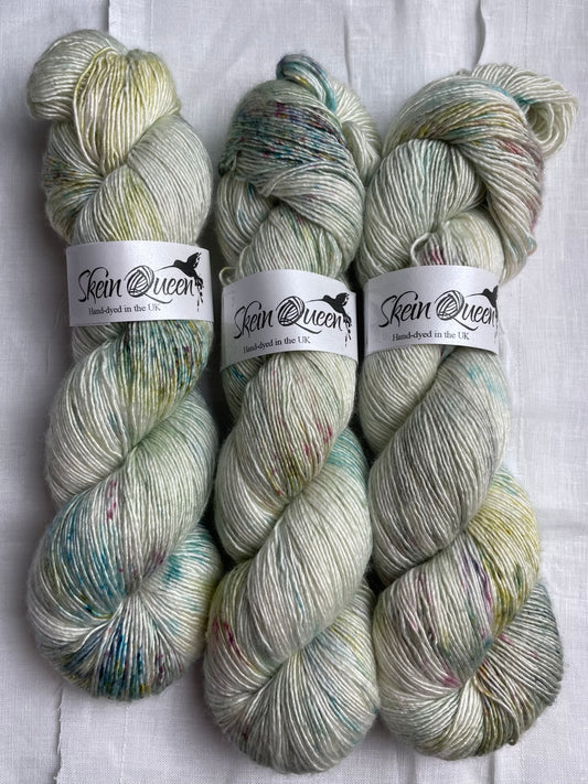 3 skeins of subtle multi coloured speckled hand dyed yarn by Skein Queen on a white background