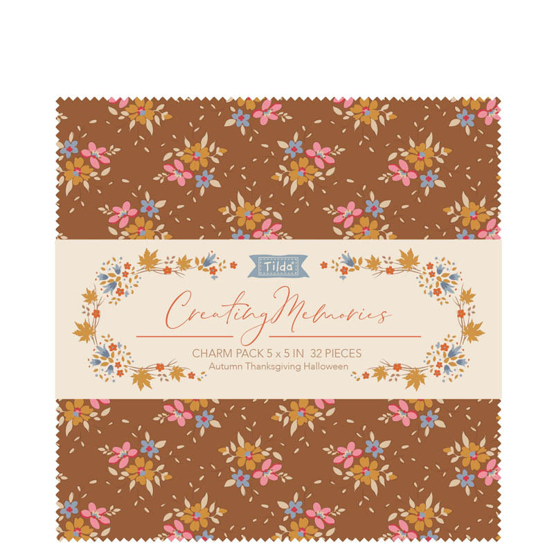 A fabric charm pack of 5" x 5" squares by Tilda  with an autumn colour theme of browns, blues and pinks in a small print, photographed against a white background.