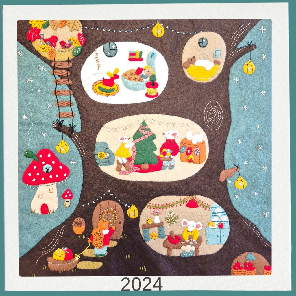 felt embroidered tree with various scenes and characters, featuring the year 2024.