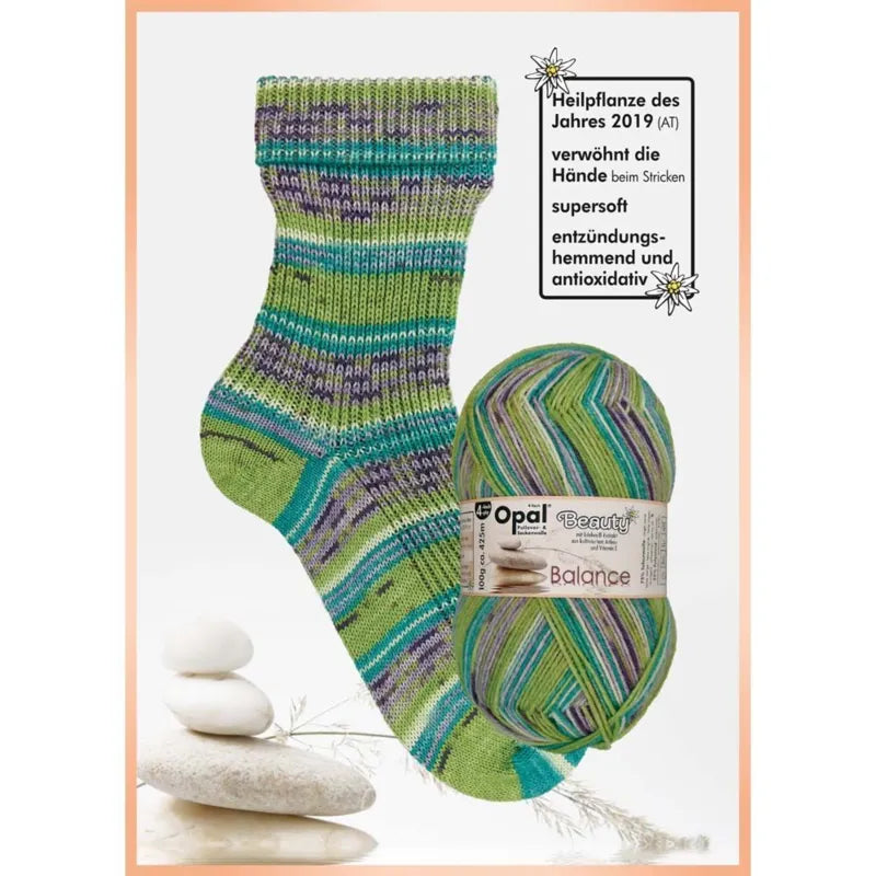 Knitted sock and ball of yarn with Opal brand label on a white background