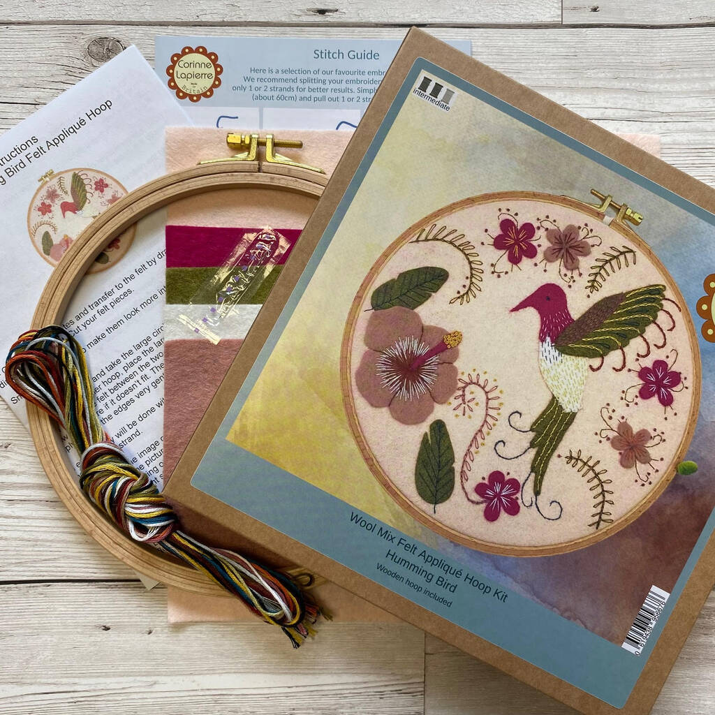 Embroidery hoop kit with hoop, thread, and pattern guide on a wooden surface
