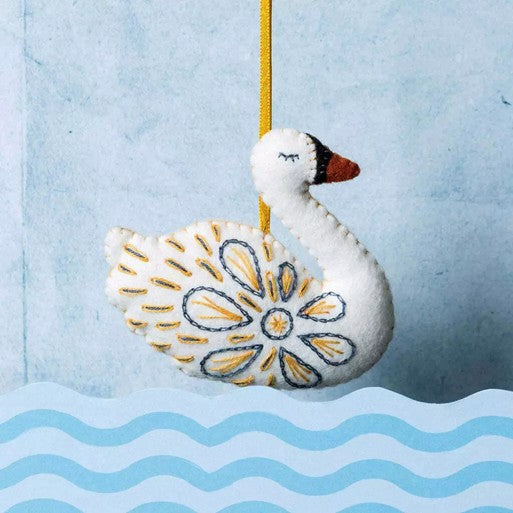 decorative embroidered felt swan on blue background.