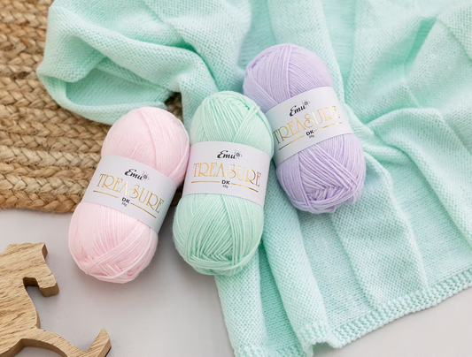 emu little treasure dk in lilac, mint and pink on a knit blanket.
