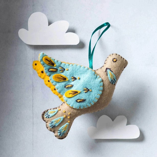 turtle doe felt decoration on plain white background with felt clouds. 