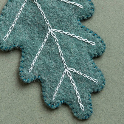 felt leaf with stitched details on grey background.